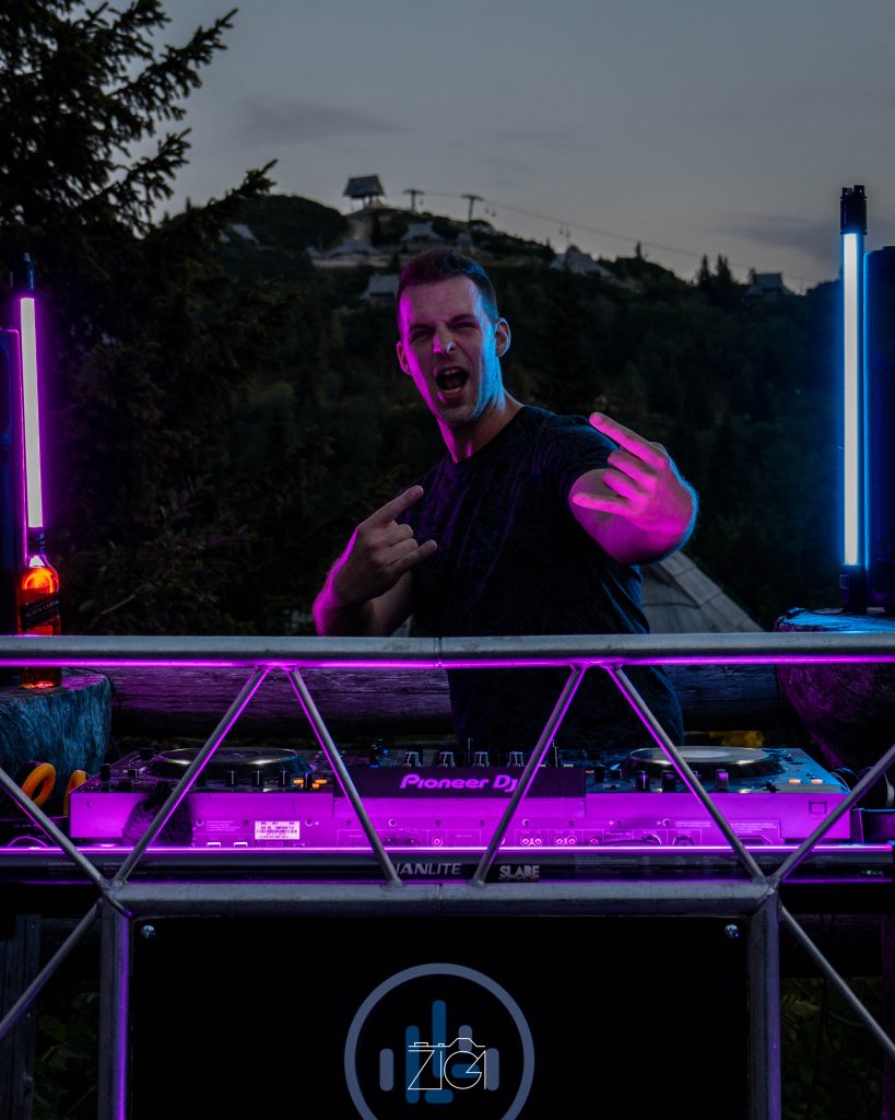 DJ za mešalno mizo v vijolični svetlobi