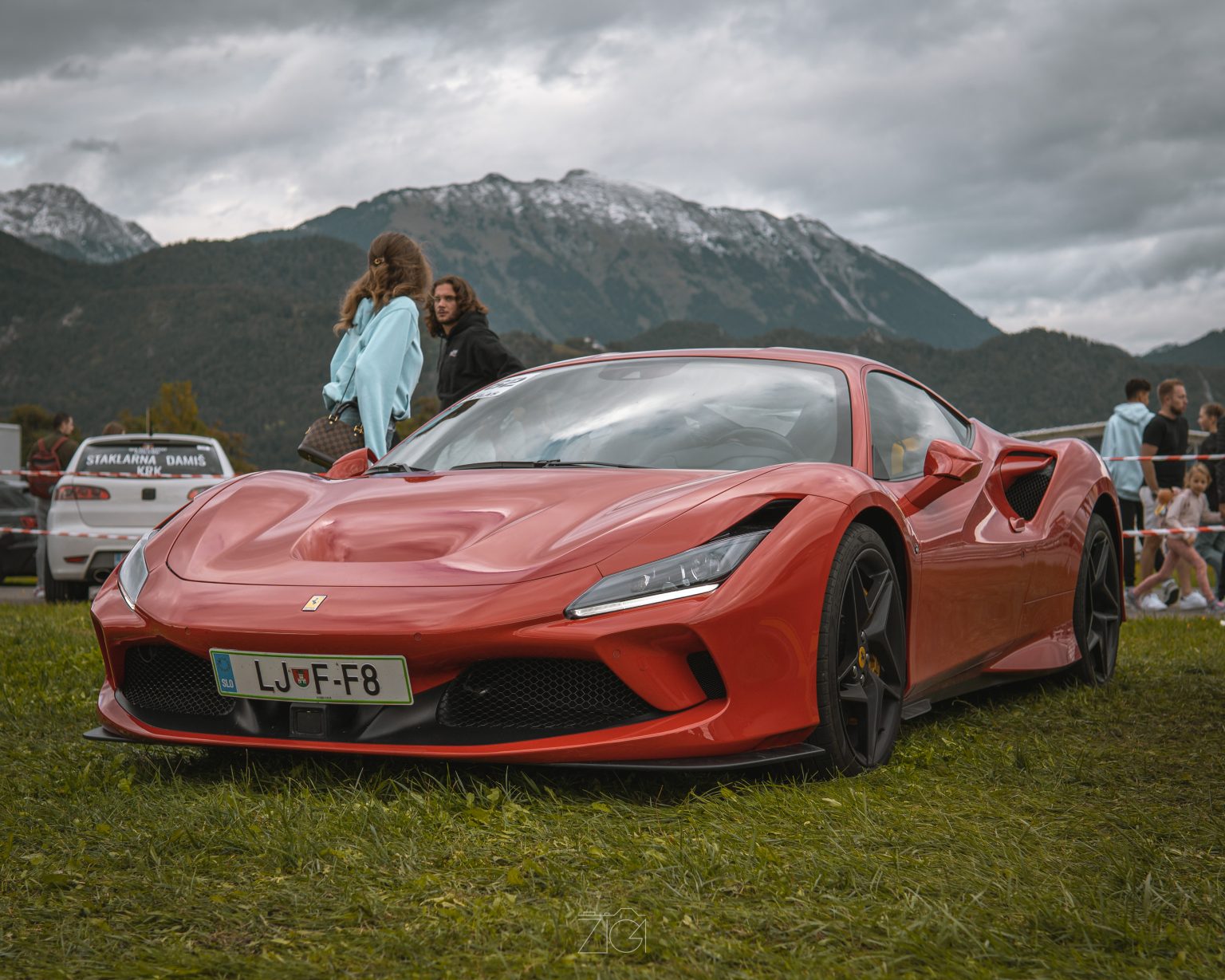 Rdeč Ferrari na travniku pod gorami